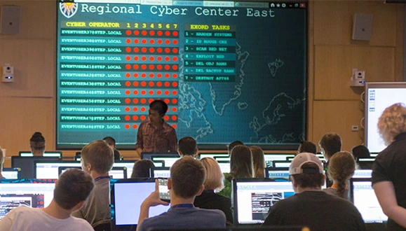 A group of high school students sitting at desks and working on their computers during the Regional Cyber Center East cybersecurity challenge.