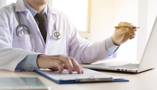 A close-up of a doctor working at their desk.