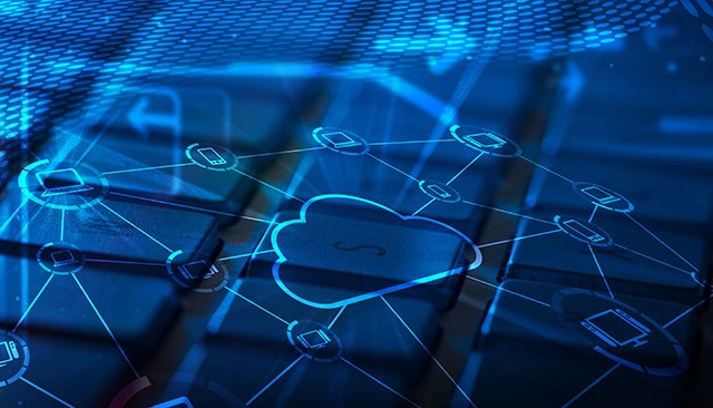 Neon blue network cloud icon connected to a network of computers in from of a close-up of a dark blue keyboard.