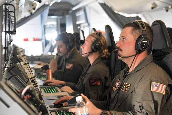 US Navy personnel operating equipment abord a maritime patrol aircraft.