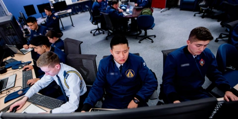 US Air Force personnel engaged in AI security training on desktop computers.