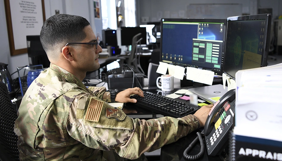 A uniformed person at a computer