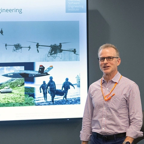 SEI employee presenting a slide detailing the Artificial Intelligence Division.