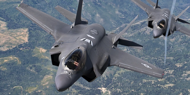 Two fighter jets flying in formation.