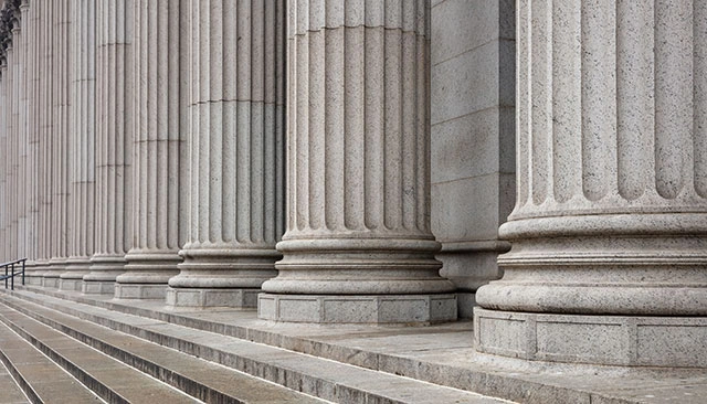 Close-up view of fluted stone columns on the exterior of a building.