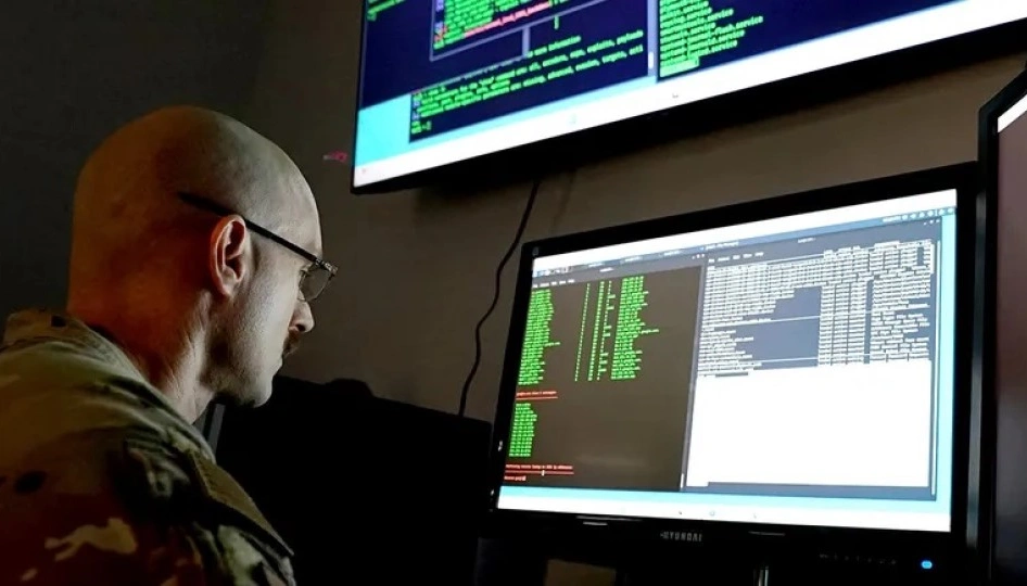Service member wearing fatigues observes a data screen.