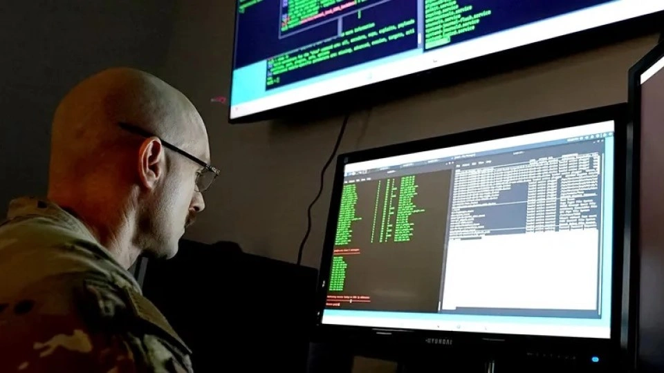 Service member wearing fatigues observes a data screen.